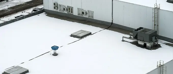 snow and ice buildup on commercial flat roof